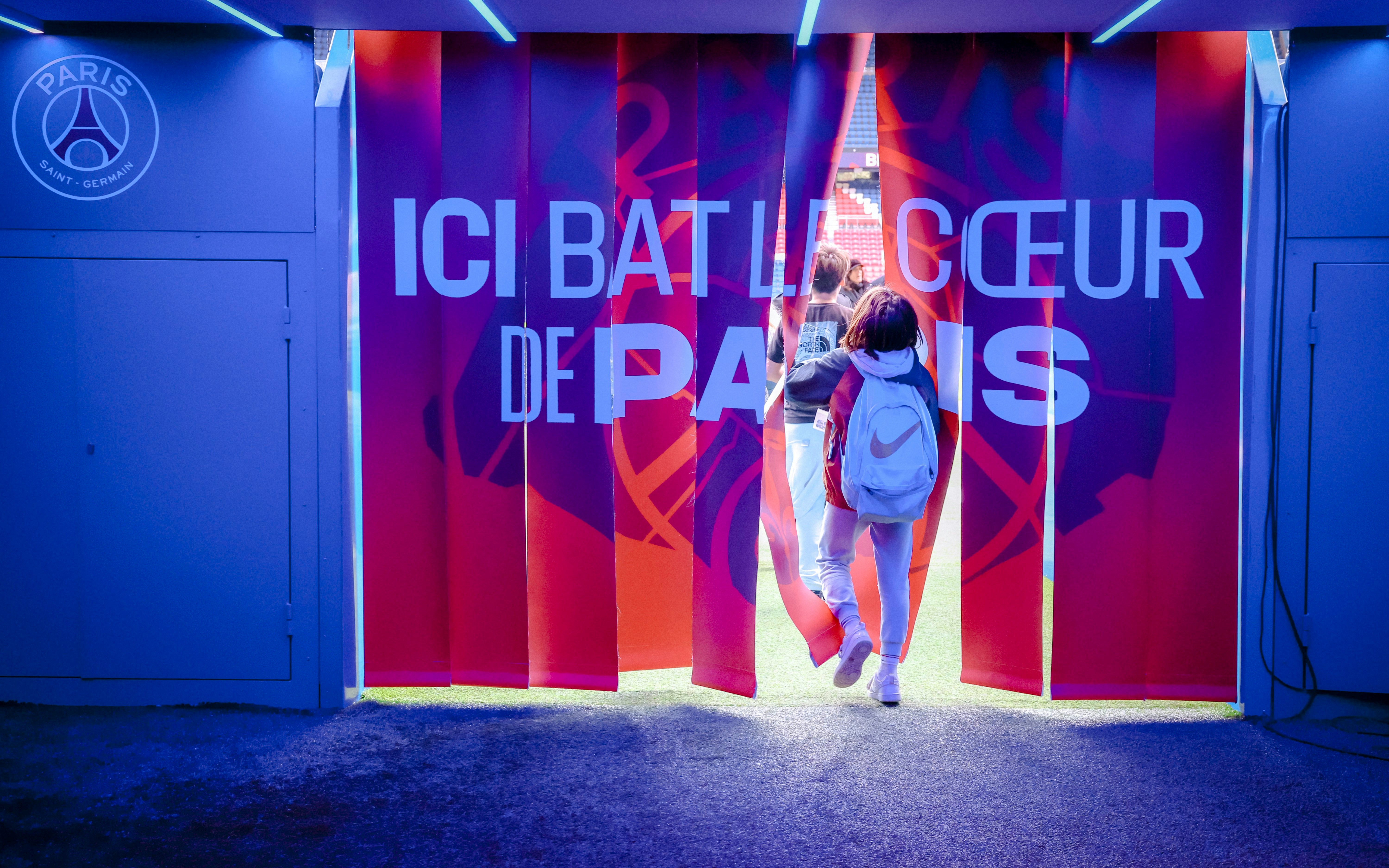 Visitors entering PSG Stadium through a tunnel in Paris, France.
