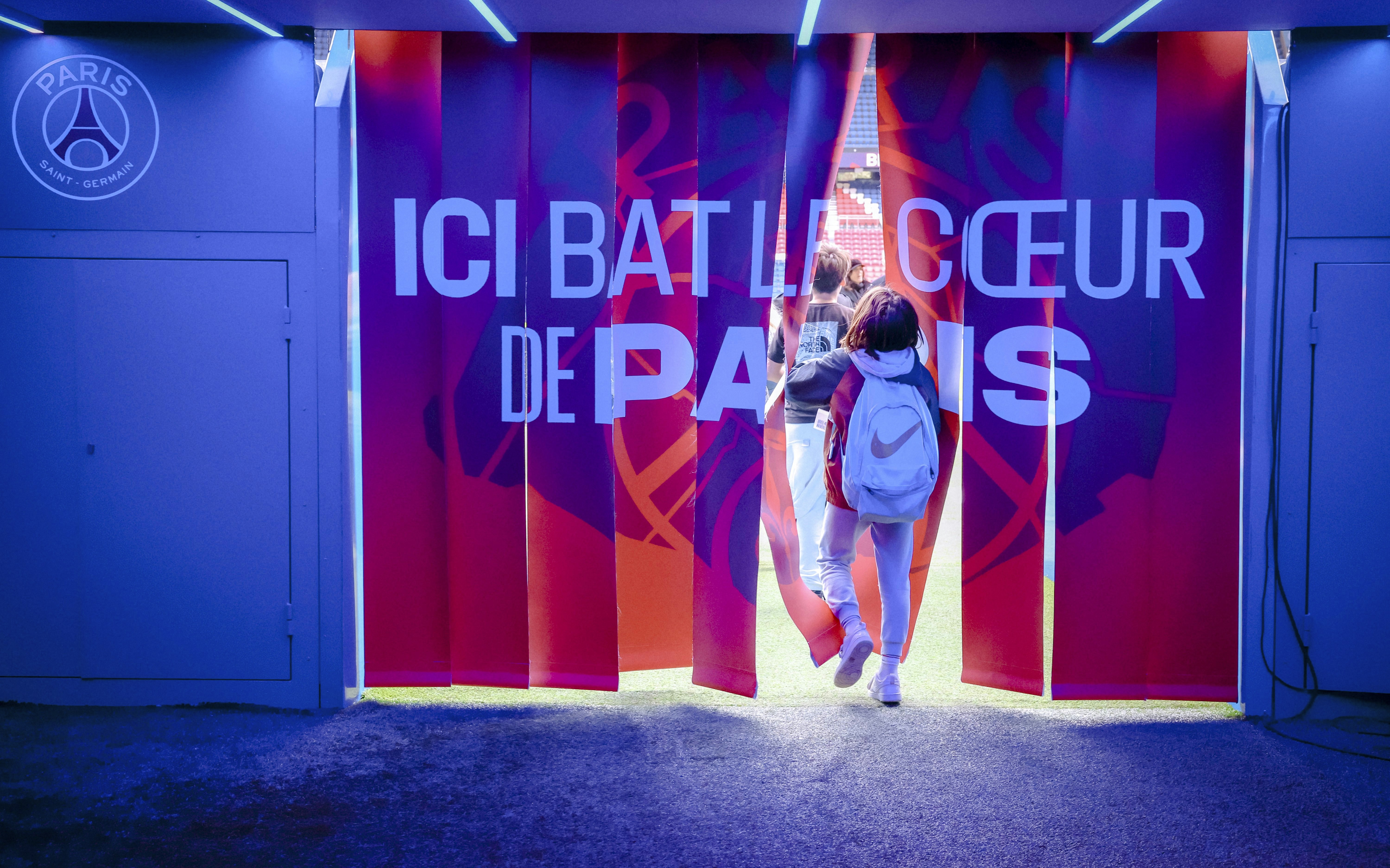 Visitors entering PSG Stadium through a tunnel in Paris, France.