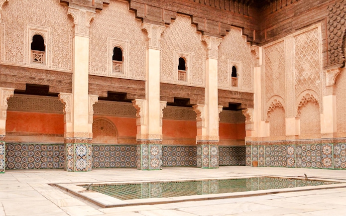 Madrasa Ben Youssef courtyard with intricate tilework and arches in Marrakech, Morocco.