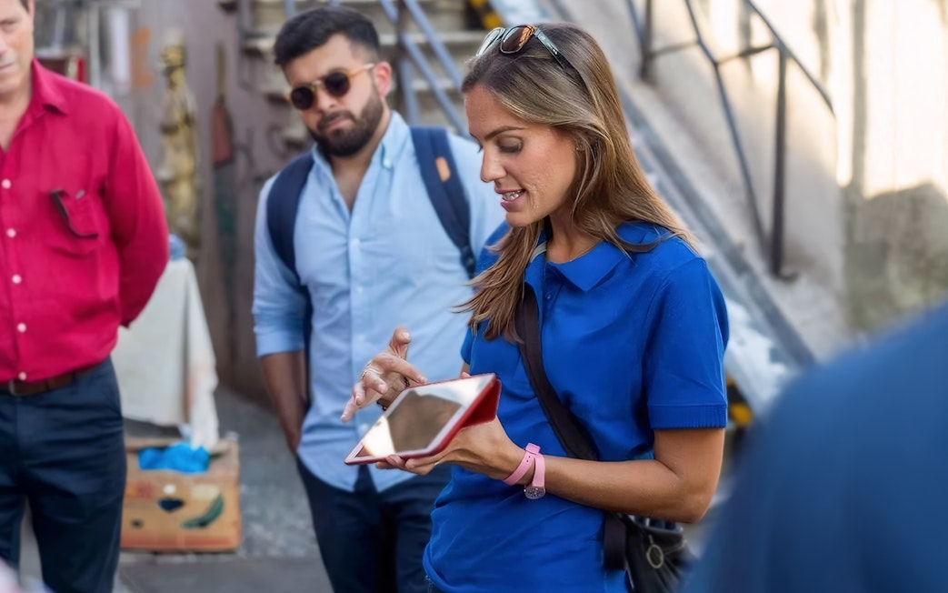 Tour guide explaining to tourists near Duomo Milan Cathedral.