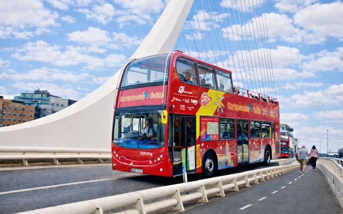 Open-top tour bus crossing Samuel Beckett Bridge in Dublin.