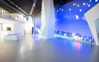 Main entrance of Remastered Rotterdam with digital art display.