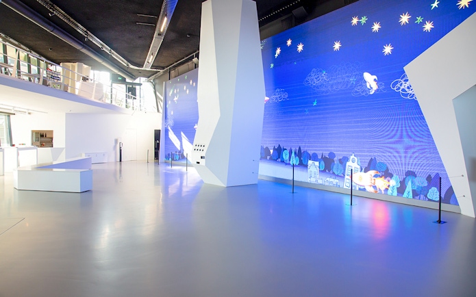 Main entrance of Remastered Rotterdam with digital art display.