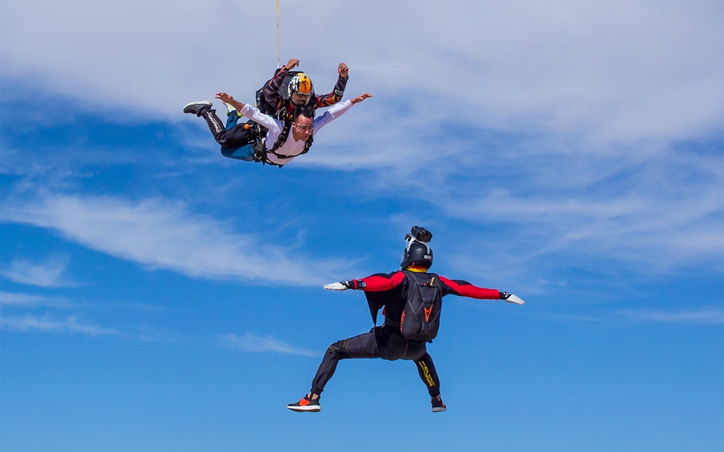 Tandem skydivers freefalling at Skydive Dubai Desert Drop Zone with instructor.