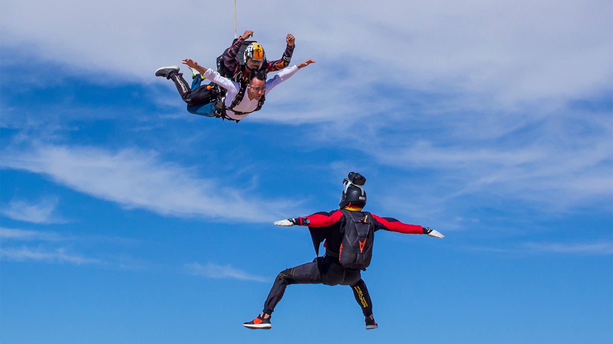 Tandem skydivers freefalling at Skydive Dubai Desert Drop Zone with instructor.