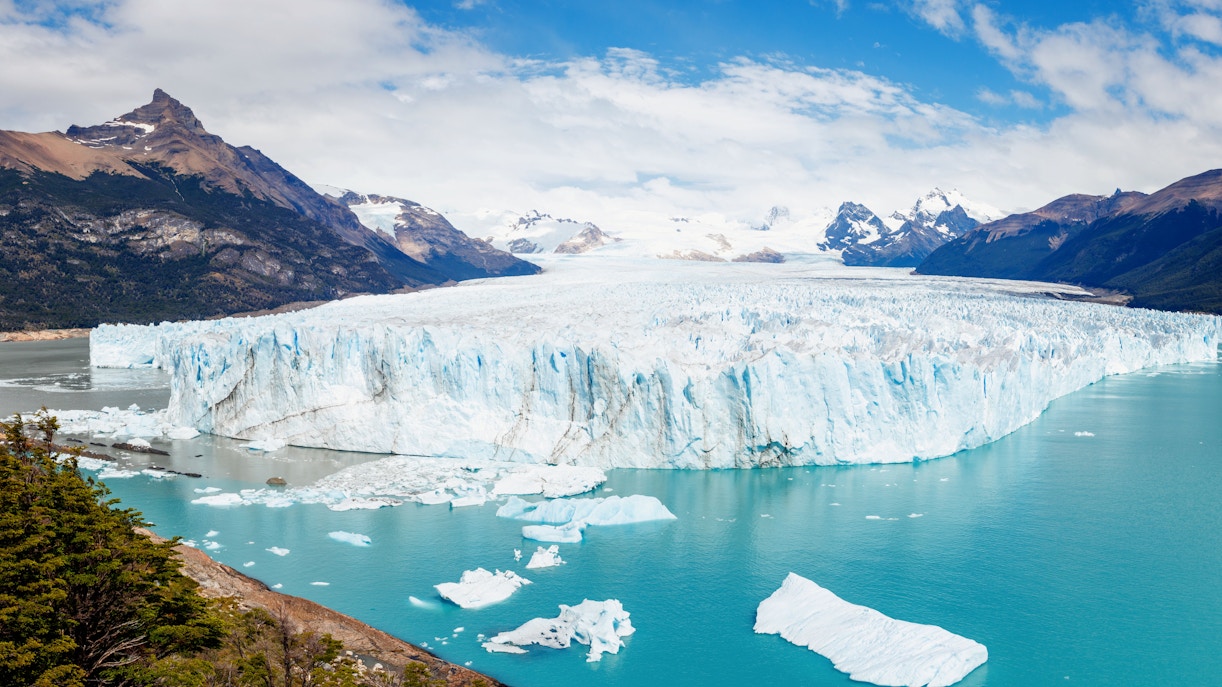 Panoramic view of Perito Moreno Glacier with icebergs and mountains in Los Glaciares National Park, Argentina.