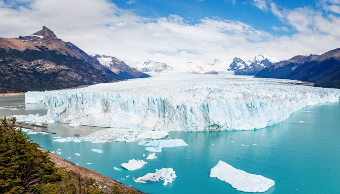 Panoramic view of Perito Moreno Glacier with icebergs and mountains in Los Glaciares National Park, Argentina.