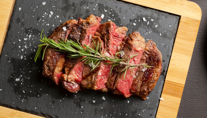 Grilled beef chorizo bife with rosemary on slate board.