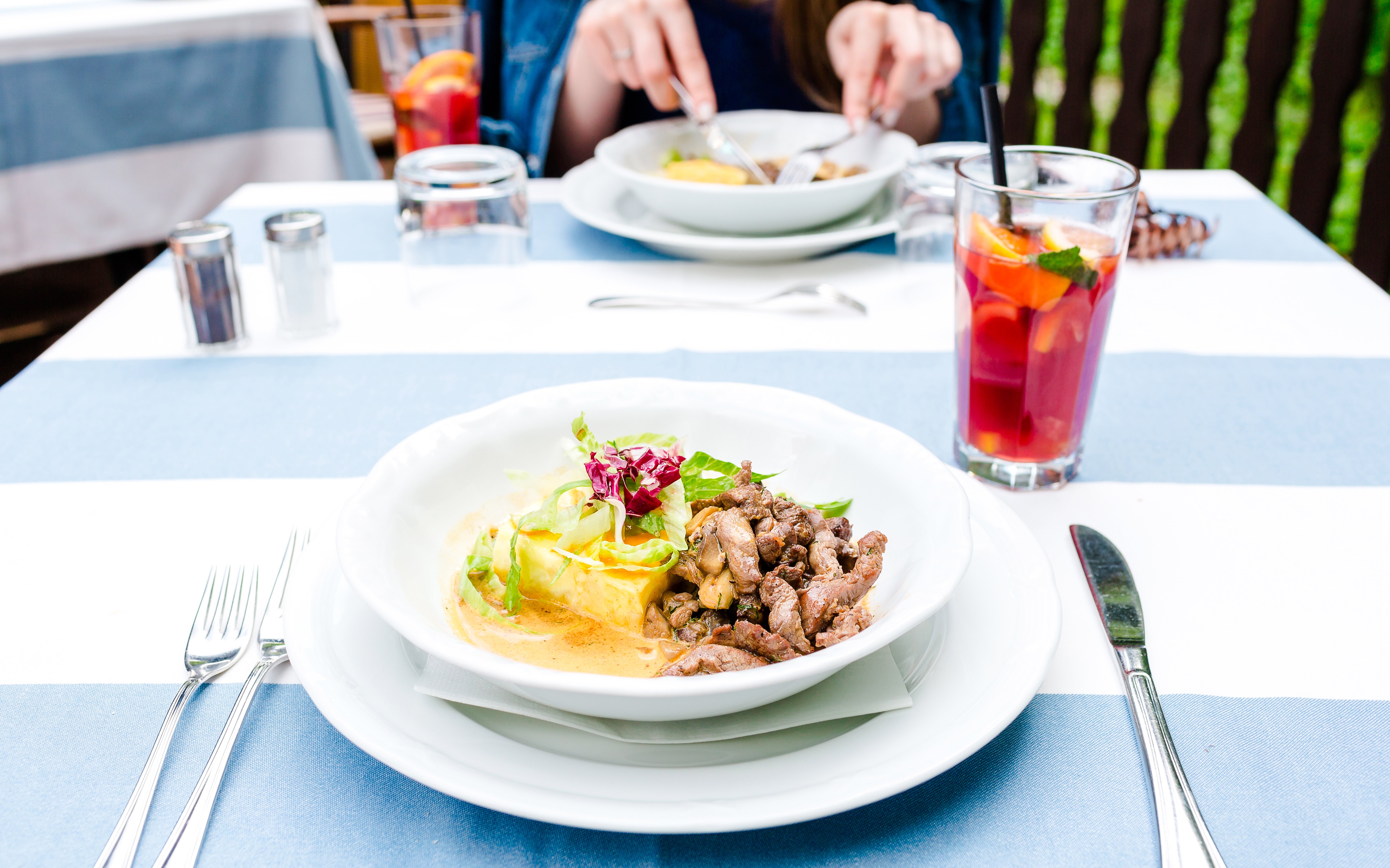Moussaka with veal served at Delphi Restaurant, accompanied by a refreshing drink.