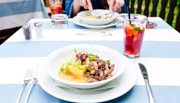 Moussaka with veal served at Delphi Restaurant, accompanied by a refreshing drink.