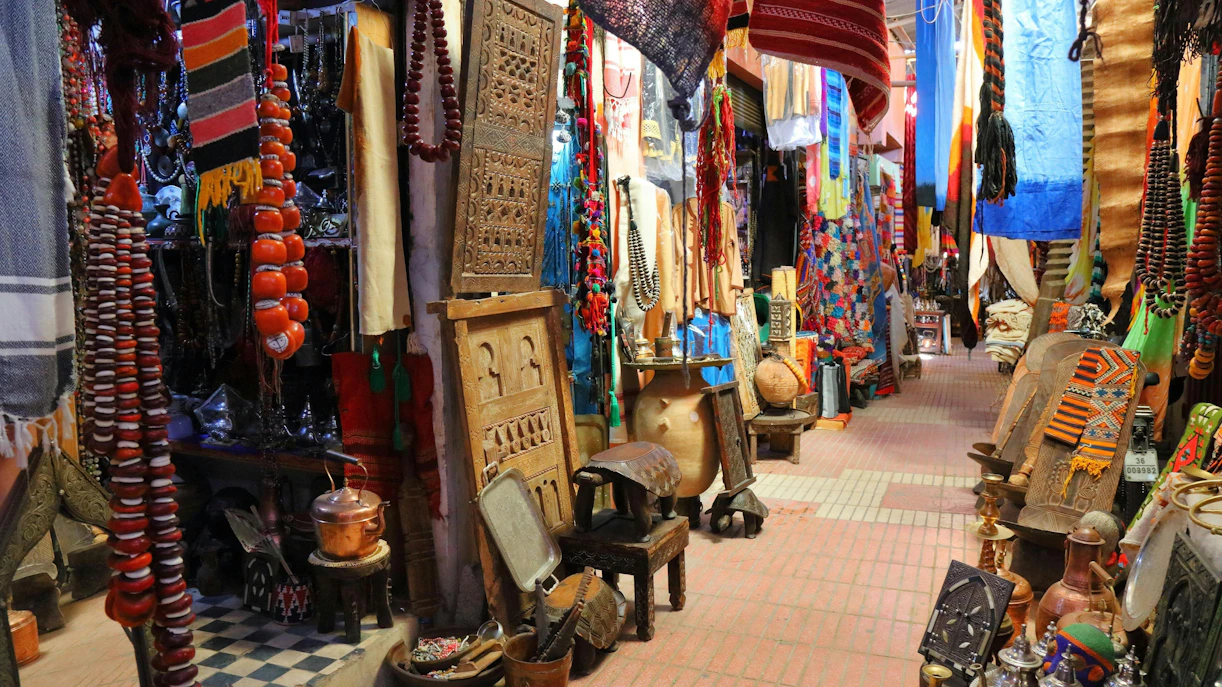 Taroudant marketplace in Morocco with colorful textiles, pottery, and traditional crafts.