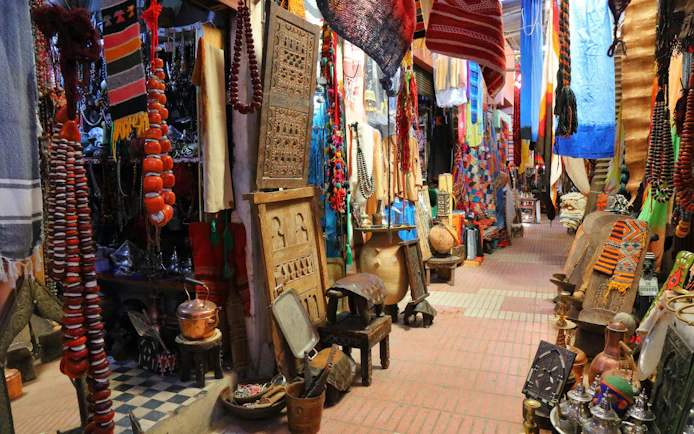 Taroudant marketplace in Morocco with colorful textiles, pottery, and traditional crafts.