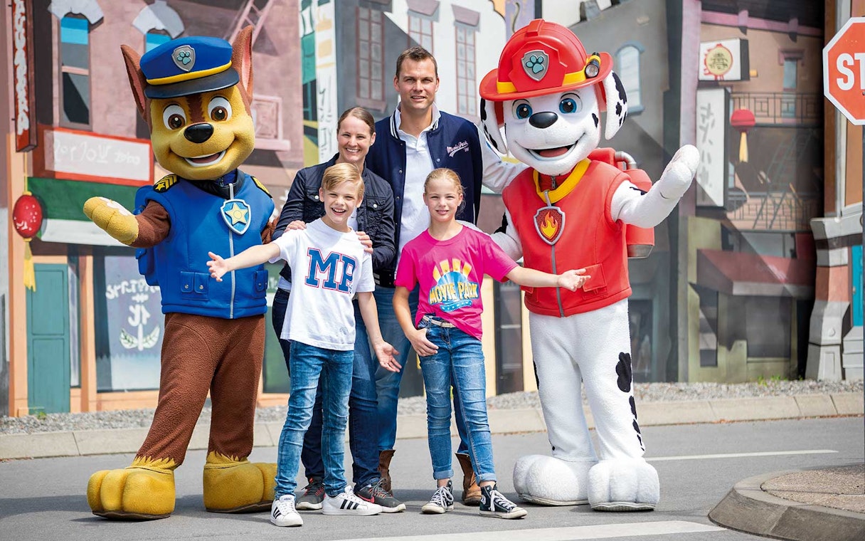 Family posing with PAW Patrol characters at Movie Park.