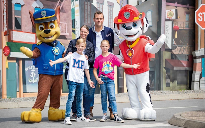 Family posing with PAW Patrol characters at Movie Park.