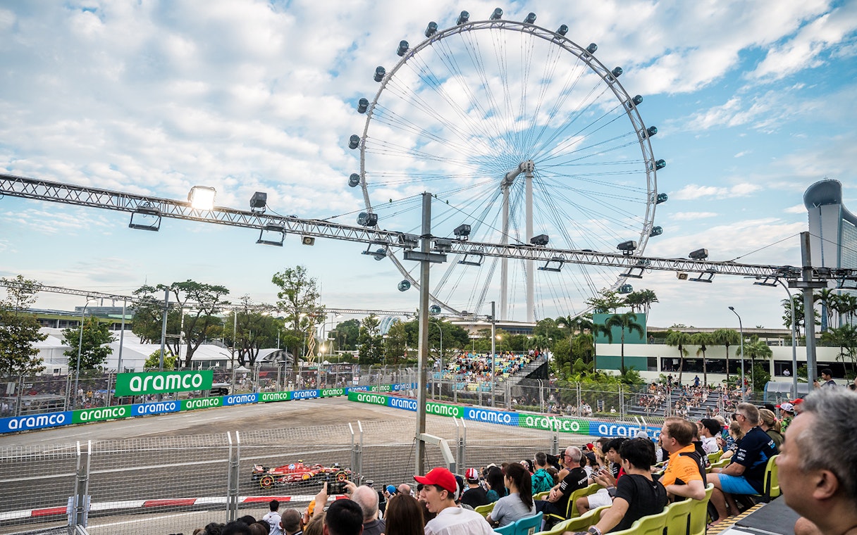 Formula 1 race at Singapore Grand Prix 2025 with Singapore Flyer in background.
