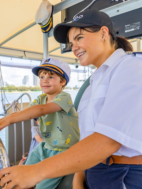 Child steering cruise ship with captain's guidance.