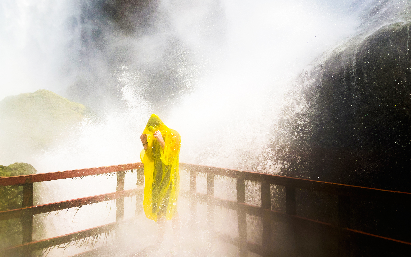 Person in yellow poncho on platform at Cave of the Winds, Niagara Falls.