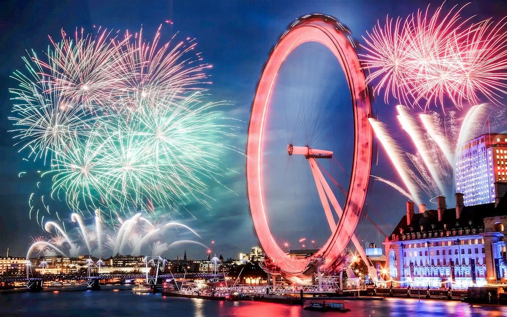 London Eye with fireworks display during New Year's celebration.