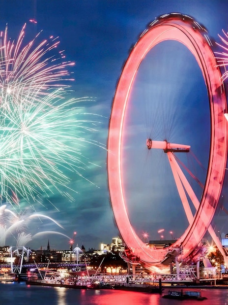 London Eye with fireworks display during New Year's celebration.