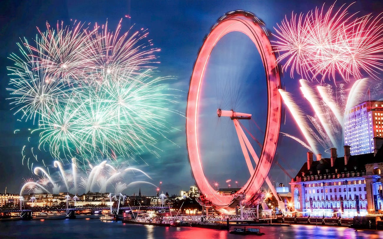 London Eye with fireworks display during New Year's celebration.