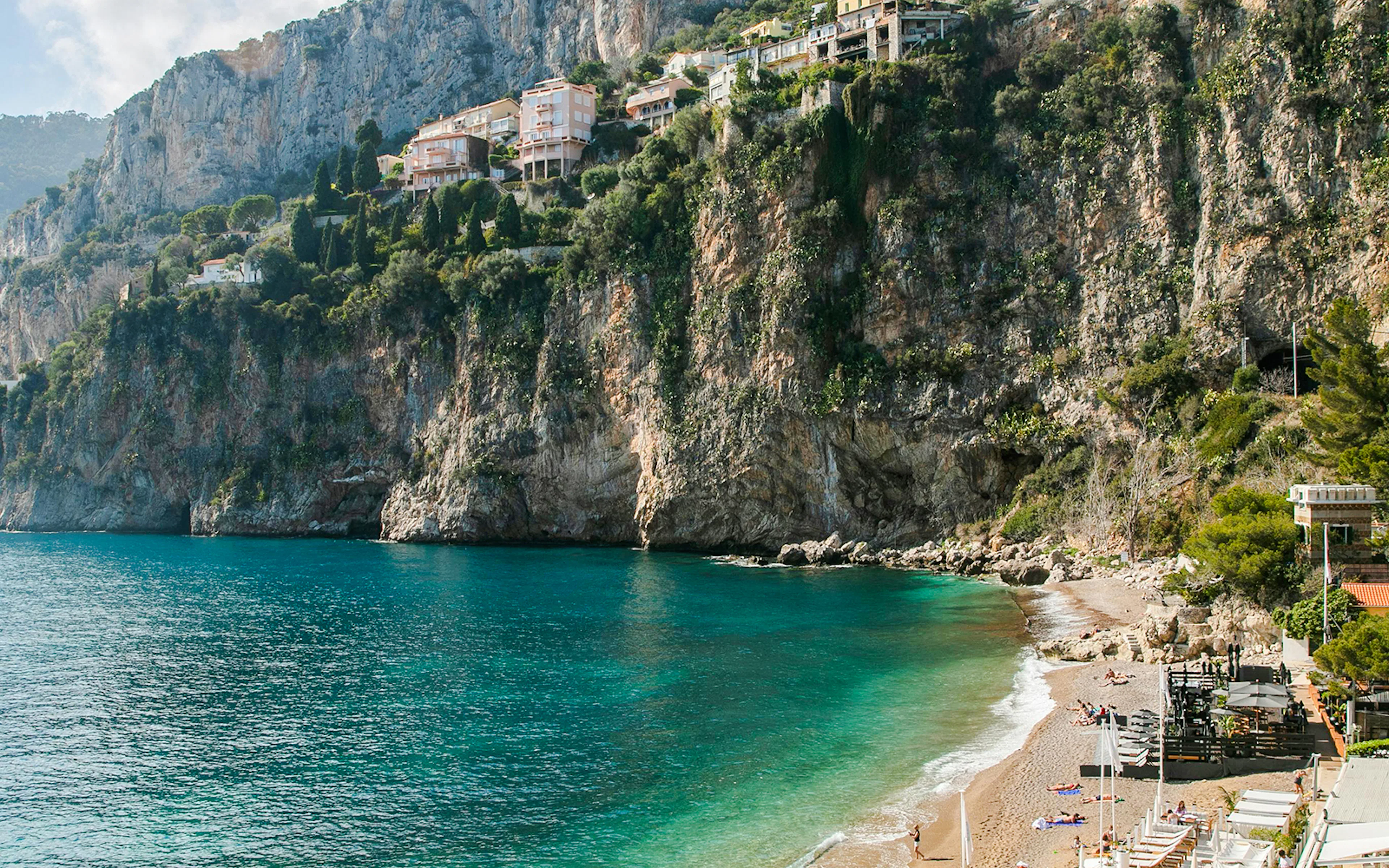 Plage de la Mala beach with turquoise water and cliffs in Nice, France.