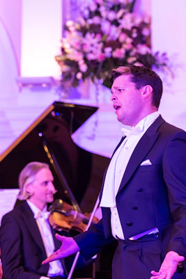 Performers at Mozart and Strauss concert in Kursalon Vienna with orchestra in background.