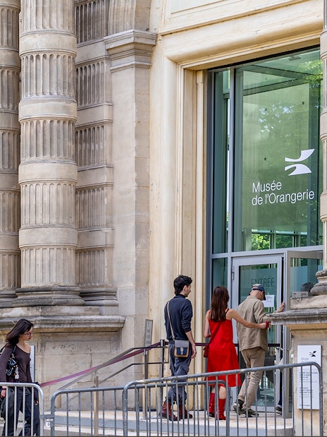 Visitors entering Musée de l'Orangerie, Paris, with its distinctive columned exterior.