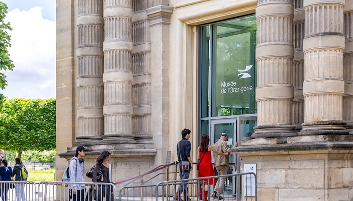 Orangerie Museum exterior in Paris with visitors walking by.