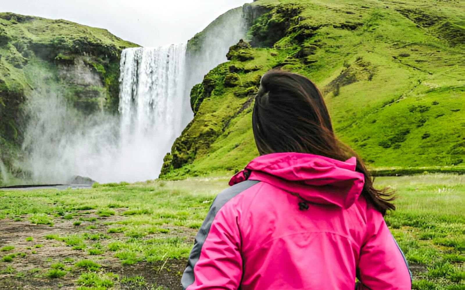 Visitor viewing Skógafoss waterfall in Iceland.