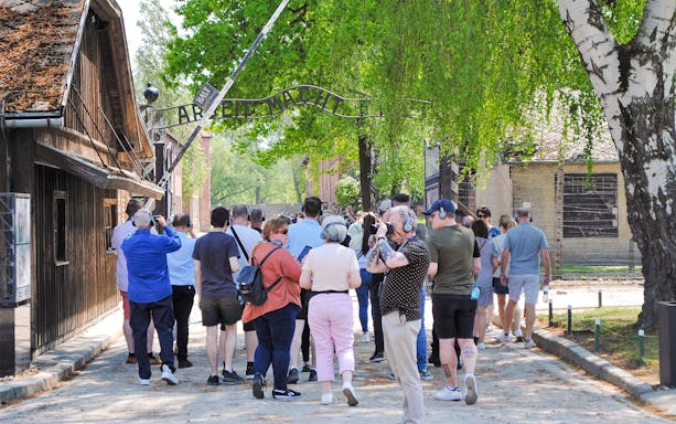 Visitors on a small guided tour entering Auschwitz I through the main gate.