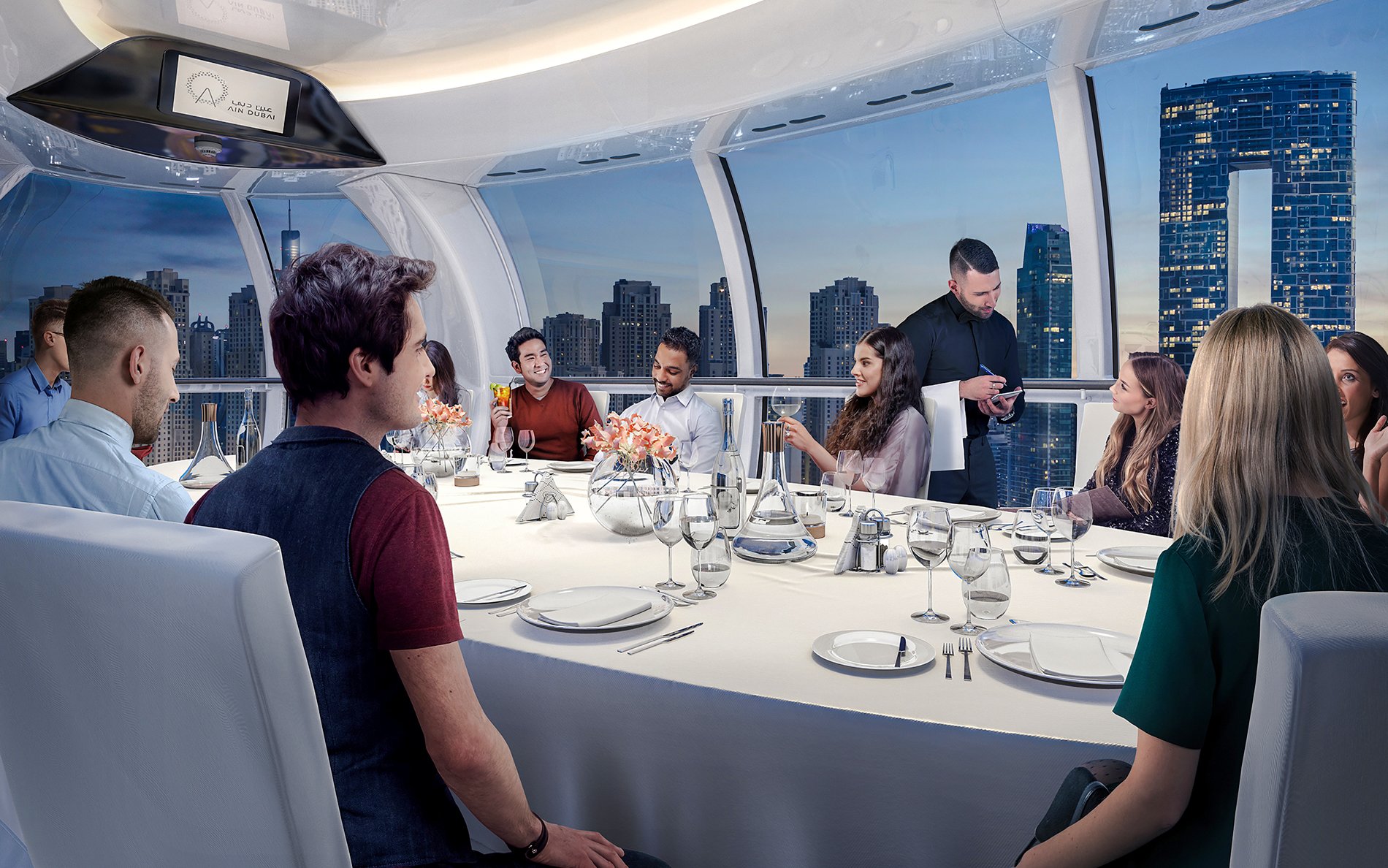 Guests dining inside AIN Dubai Wheel with city skyline views.