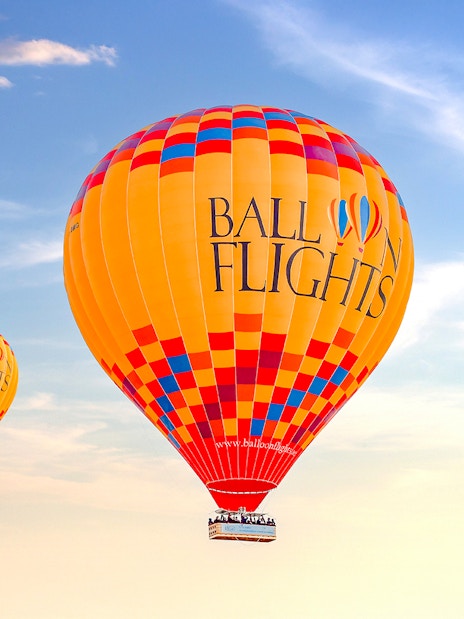 Hot air balloons in flight against a clear sky, promoting a limited time offer for two.