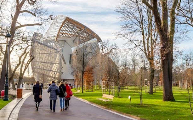 Visitors walking towards the Foundation Louis Vuitton building in Paris.