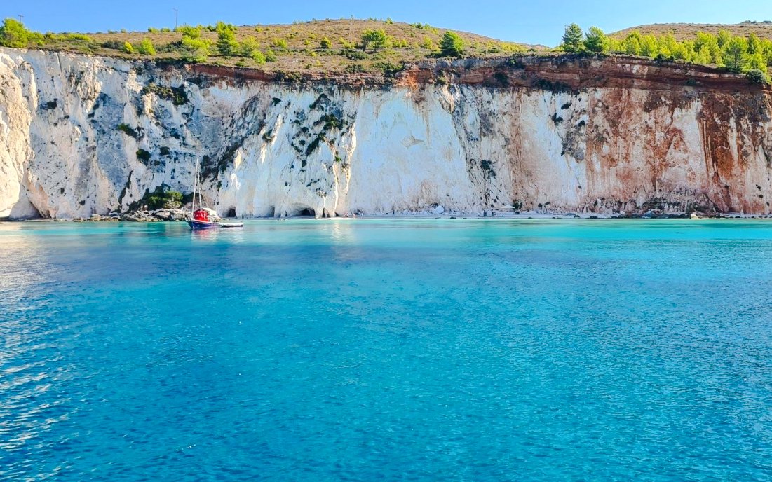 Sailboat near white cliffs on a daily cruise from Kefalonia.