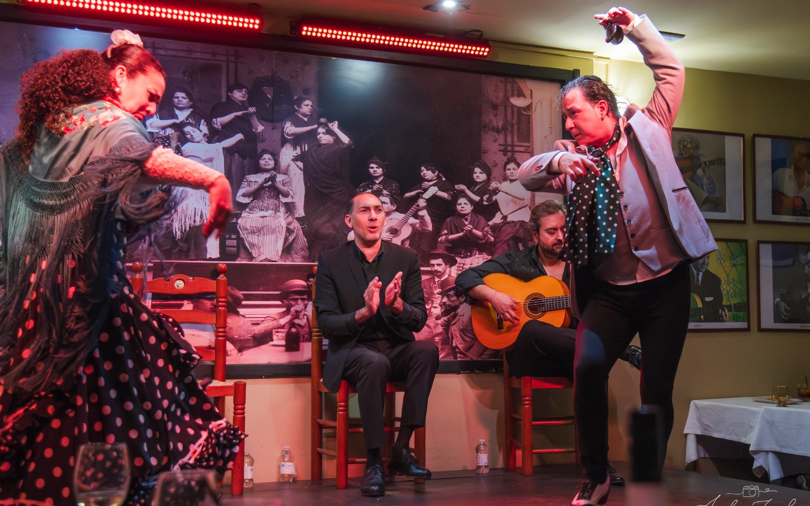 Flamenco dancers performing at Tablao La Cantaora, Seville with guitarist and clapping audience.