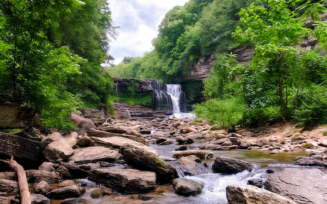 Waterfall cascading over rocks surrounded by lush greenery in Chiang Mai.