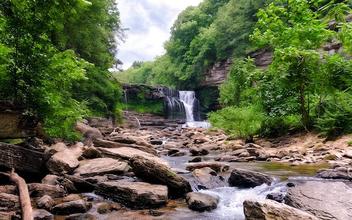 Waterfall cascading over rocks surrounded by lush greenery in Chiang Mai.