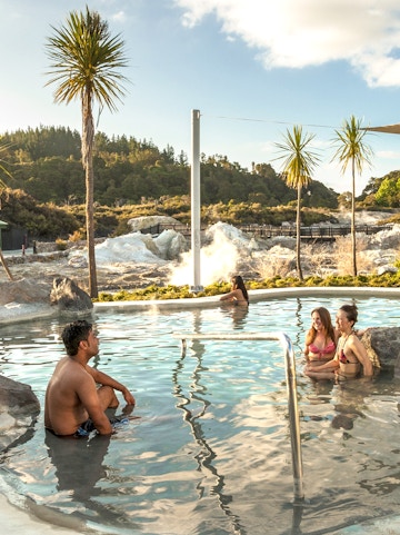 Visitors relaxing in geothermal pool at Hell's Gate Geothermal Reserve, New Zealand.