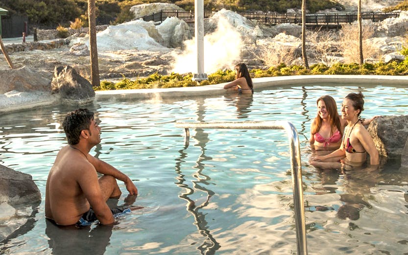 Visitors relaxing in geothermal pool at Hell's Gate Geothermal Reserve, New Zealand.