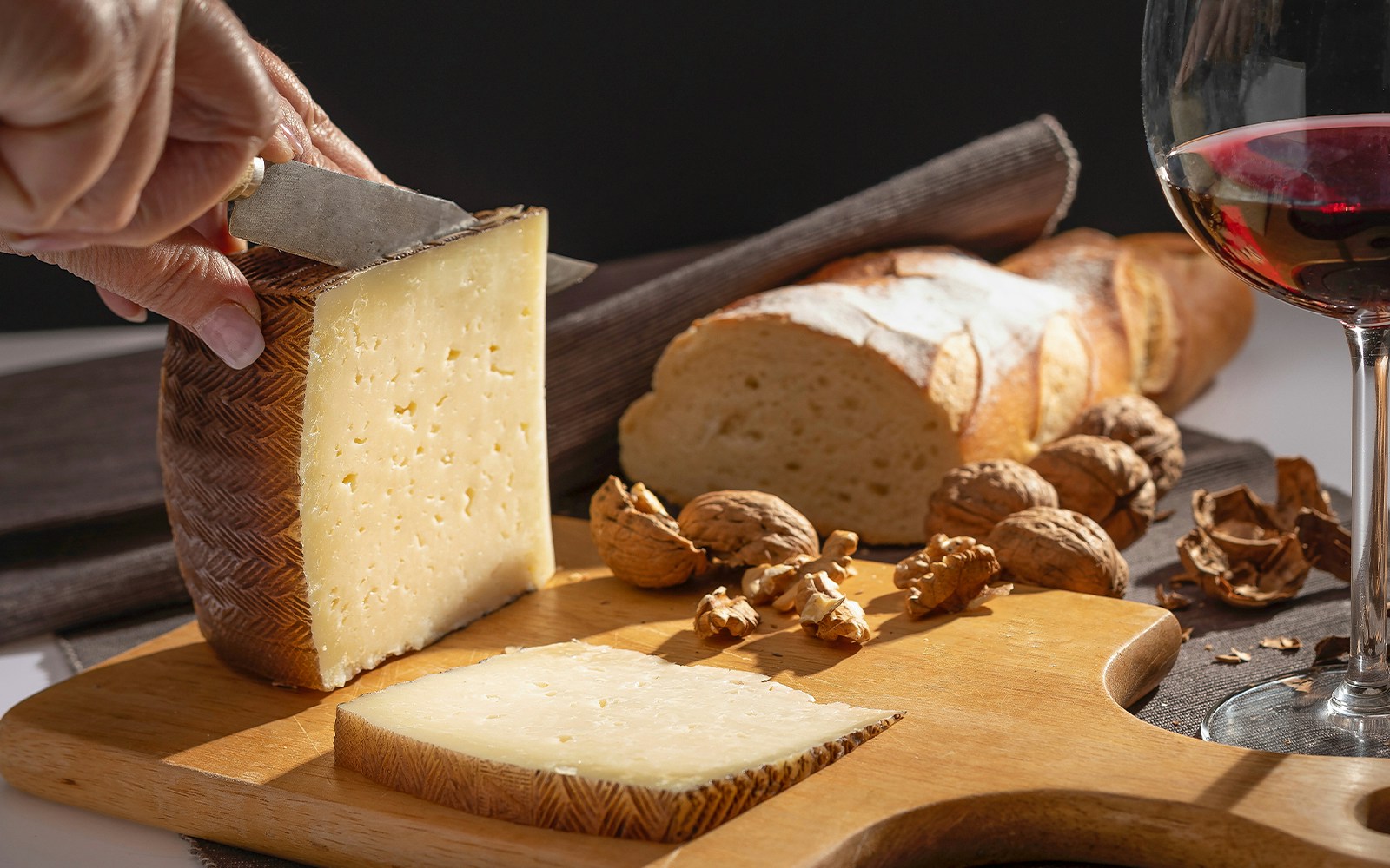 Manchego cheese and nuts on a wooden table in Madrid, Spain.