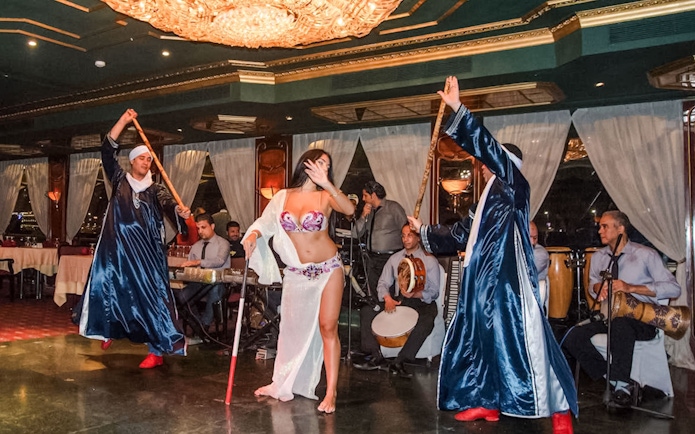 Dancer performing with musicians on a luxury Nile dinner cruise.
