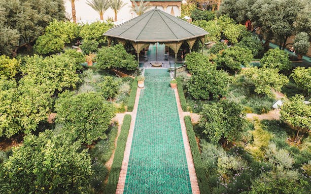 Jardin Secret pavilion surrounded by lush greenery in Marrakech, Morocco.