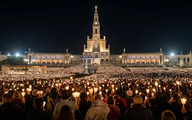 Candlelight procession at Fatima Sanctuary during night pilgrimage tour.
