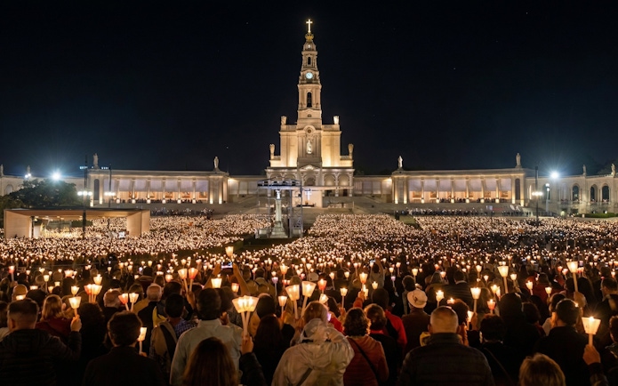 Candlelight procession at Fatima Sanctuary during night pilgrimage tour.