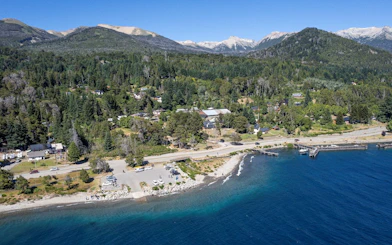 Aerial view of Villa La Angostura with Nahuel Huapi Lake shoreline and forested hills.