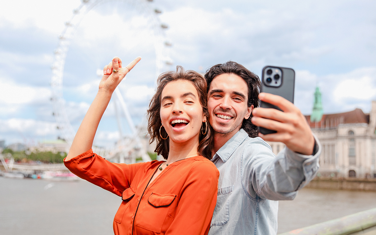 Couple taking a selfie with the London Eye in the background during a champagne experience.