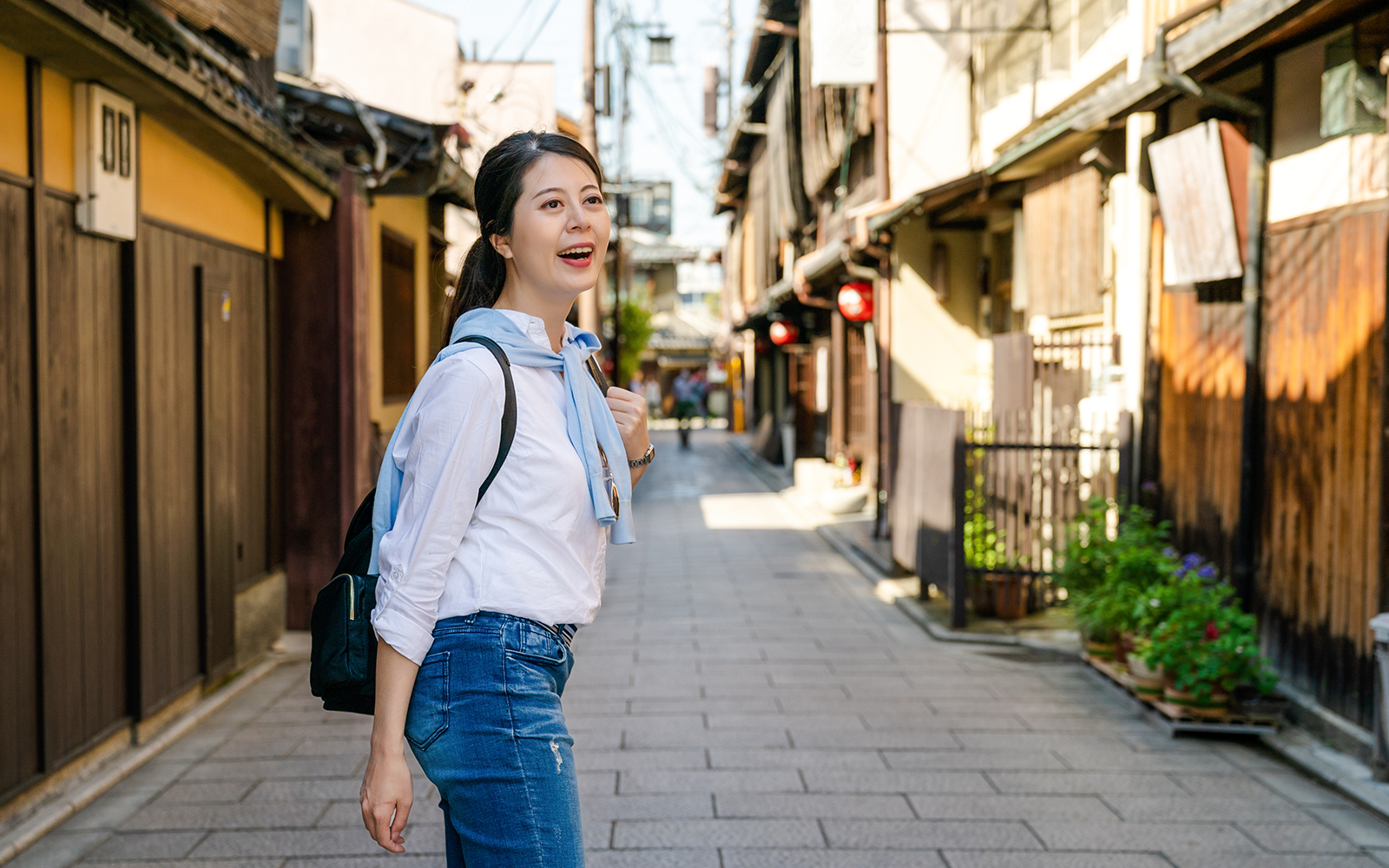 Woman walking through historic Hanamikoji street on a day trip.