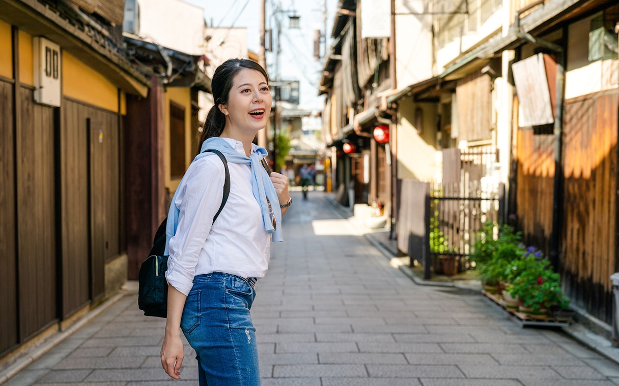 Woman walking through historic Hanamikoji street on a day trip.