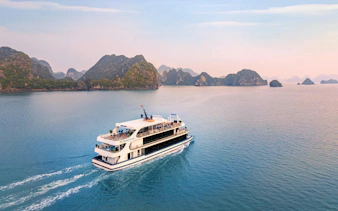 Luxury cruise ship sailing in Ha Long Bay with limestone islands in the background.