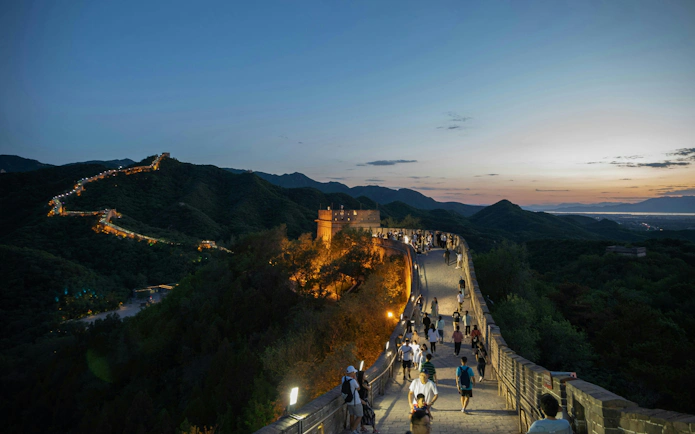 Visitors walking on the illuminated Badaling Great Wall at night, Beijing.